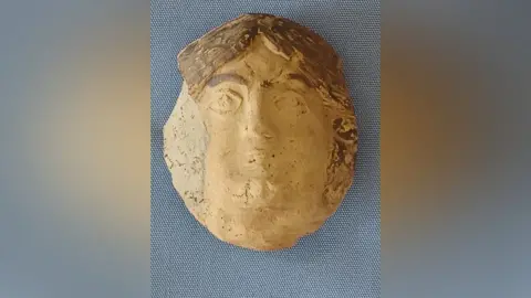 Historic England A face painted on to a piece of pottery