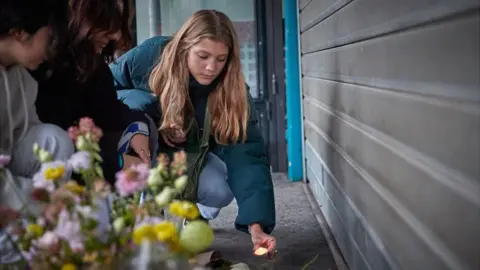 Getty Images Parisians light candles in memory of the victims of the 13 November 2015 Paris terror attacks at La Belle Equipe restaurant, one of the scenes of the attacks, France, 2021