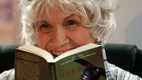 Canadian author Alice Munro holds one of her books as she receives her Man Booker International award at Trinity College Dublin, in Dublin, Ireland, on June 25, 2009.