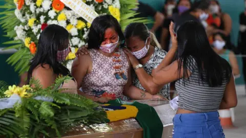 AFP Indigenous from the Parque das Tribos community mourn besides the coffin of an indigenous leader