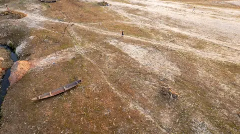 Lucas Amorelli / Sea Shepherd A canoe rests on the bank of a dried-out creek