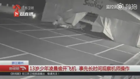Jiangsu TV A boy removing a plane from a hangar of an airport