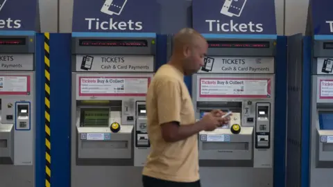 Getty Images Man walks past ticket machines