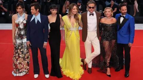 Getty Images (Left to right) Gemma Chan, Harry Styles, Sydney Chandler, Olivia Wilde, Chris Pine, Florence Pugh and Nick Kroll on the red carpet ahead of the Don't Worry Darling screening at the Venice Film Festival