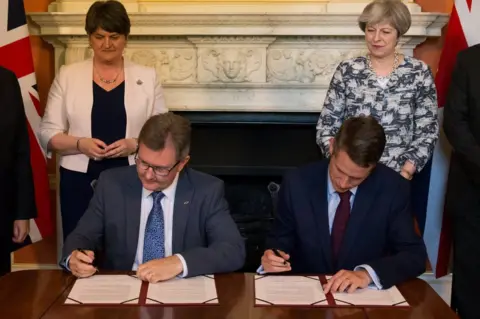 Reuters The deal was signed in Downing St by DUP MP Sir Jeffrey Donaldson and Tory Chief Whip Gavin Williamson