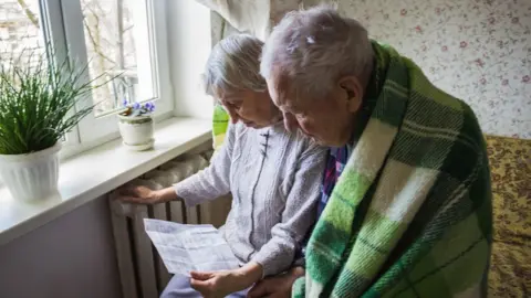 Getty Images Elderly couple look at heating bill