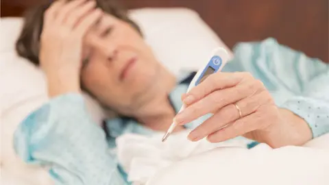 Getty Images Woman in bed with flu