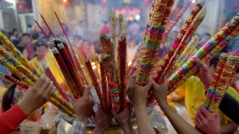 Getty Images Cambodian-Chinese place various sizes of incense sticks into an urn at a temple to mark the start of the Lunar New Year in Kandal on February 16, 2018