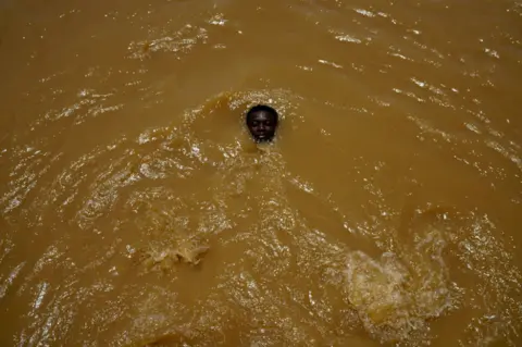 Reuters A boy head is seen above the water. His eyes are closed, and the rest of his body is submerged.