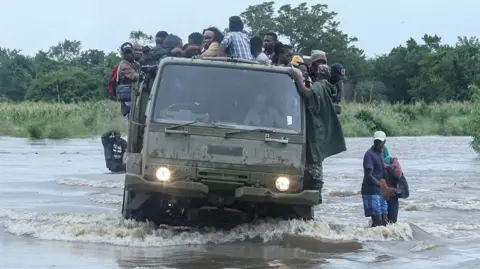 Mozambican residents are seen at the back of a military truck as they are rescued from a flooded area in the country