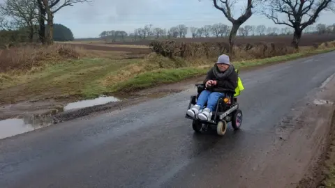 Adam Stanton-Wharmby  Adam Stanton-Wharmby driving his wheelchair