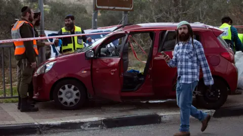 AFP Israeli forensic specialists inspect a a car at the site of a deadly attack near the Jewish settlement of Ariel in the occupied West Bank (17 March 2019)