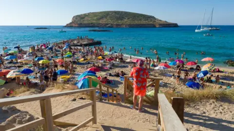 Getty Images Tourists on a beach in Ibiza