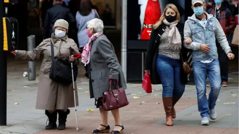 Reuters People wearing masks in Manchester