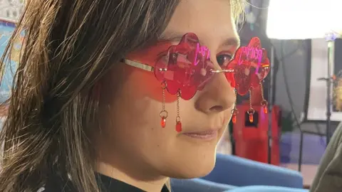 Teenager wearing pink cloud glasses