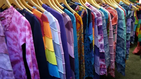 Clothes on hangers at a market stall