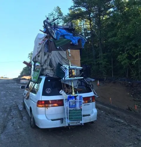 Facebook New Hampshire State Police post a photo of a van overloaded with household items including a table, a television and a shopping cart strapped to the outside of the vehicle.