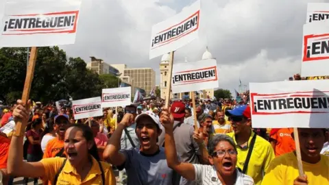 Reuters Opposition supporters hold placards that reads "Deliver" as they attend a rally in support of Juan Pablo Guanipa, elected governor of Zulia state, in Maracaibo, Venezuela October 24, 20