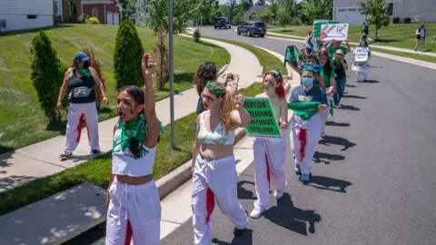 Getty Images Abortion rights activists march near the home of Supreme Court Justice Amy Coney Barrett on 18 June 2022 in Falls Church, Virginia