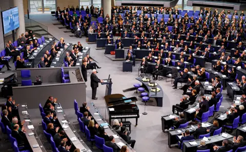 Michelle Tantussi / Reuters Klaus Schirdewahn, a representative of the queer community, speaks during a memorial ceremony commemorating the victims of the Holocaust at the lower house of the parliament or Bundestag, in Berlin, Germany, on 27 January 2023