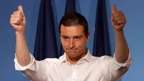 AFP Jordan Bardella gestures at the audience during a campaign meeting