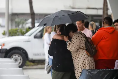 Reuters People embrace at the Surfside Community Center where authorities are taking residents and relatives from a partially collapsed building in Surfside near Miami Beach, Florida, U.S., June 24, 2021.