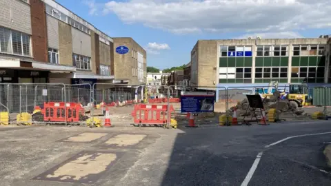 View of ongoing building works as fencing surrounds deserted shop buildings