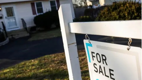 House with a "for sale" sign in front of it