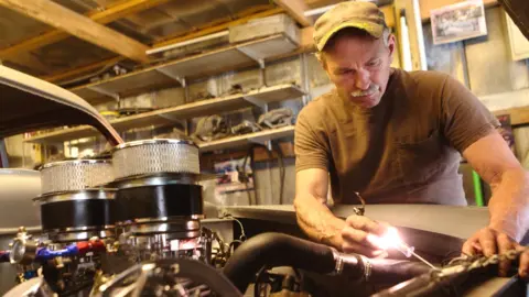 Man working on car engine