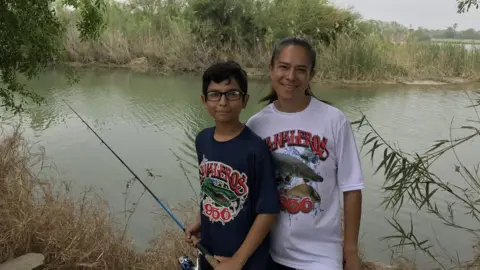 Family fishing on banks of river