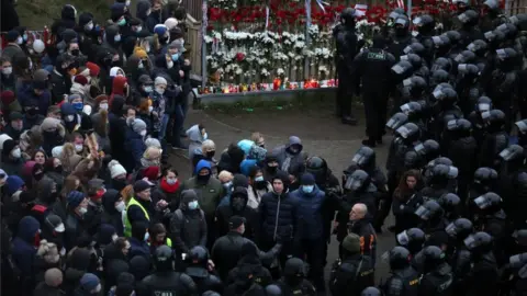 EPA Belarussian policemen talk to protesters before detaining them during an anti-government rally in Minsk