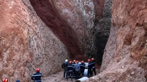 Getty Images Rescue crews work to reach five-year-old boy Rayan, who became trapped after falling into a well in Morocco