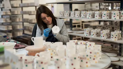 Getty Images A worker hand-paints crockery in a factory