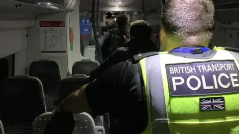 BTP British Transport Police helping passengers off a train