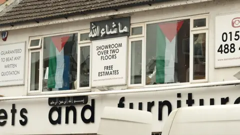 Stephen Huntley/BBC Palestinian flags draped in a Luton shop window