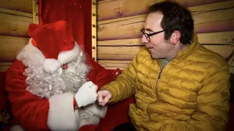 Visitor fist bumping Santa