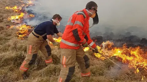 Steve Gribbon Firefighters tackling a blaze at Lyme Park