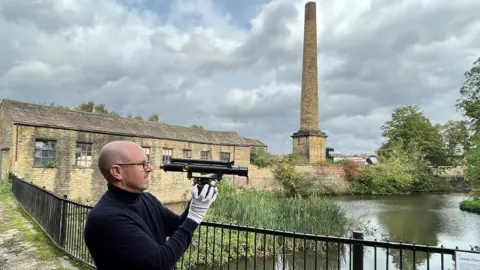 Leeds Industrial Museum Curator John McGoldrick with a vintage theodolite