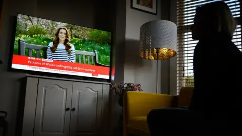 Getty Images A woman watches Catherine on BBC News on a screen