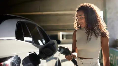 Getty Woman charging electric car