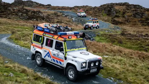 Cockermouth Mountain Rescue Team CMRT vehicles driving down the pass above Honister Slate Mine