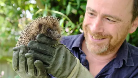 Hugh Warwick  Hugh Warwick with a hedgehog