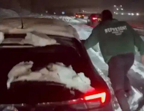 Greg Leigh/Instagram Stories Man helping car in snow on M25