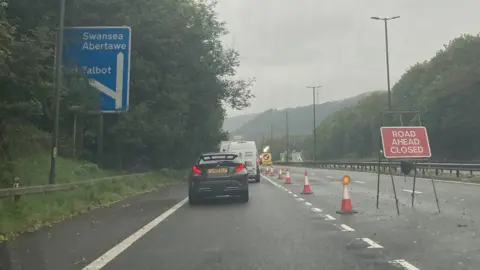 BBC Queueing traffic and a road closed sign at junction 38 of the M4