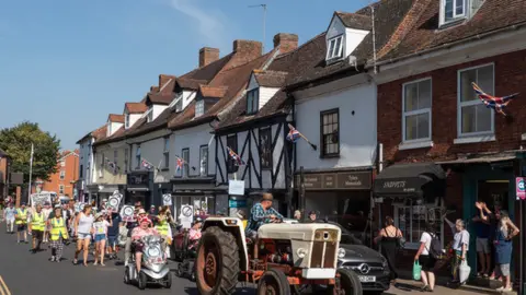 Future Newent A tractor leading a group of protestors down a road