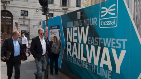 In Pictures / Getty Images People walk past billboards promoting Crossrail's new Queen Elizabeth rail line in Moorgate, London