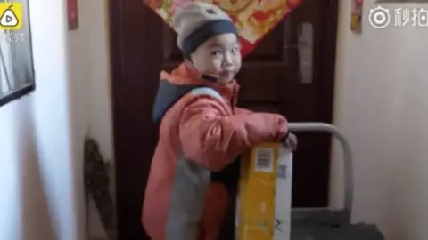 Pear Video Seven-year-old Chang Jiang holding a parcel