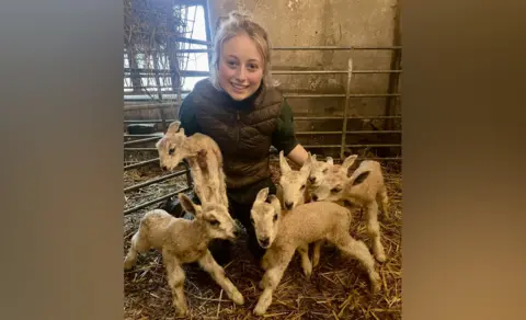 Erin Fflur McNaught/Twitter Erin holding the lambs