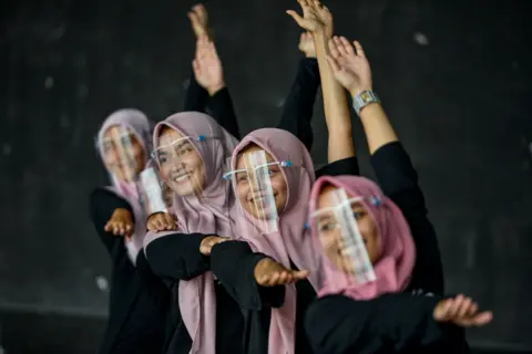 CHAIDEER MAHYUDDIN / AFP Dancers wearing face shields perform during a rehearsal