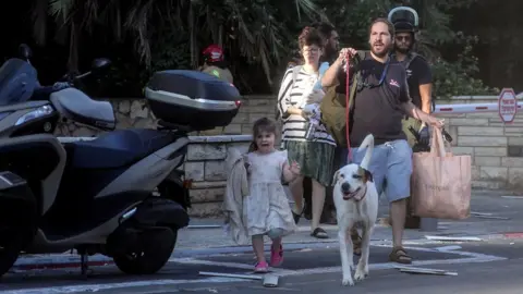 Reuters Israelis react on a street as rocket attacks are launched from the Gaza Strip, in Tel Aviv, Israel October 7, 2023